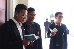 Beberapa mahasiswa menghafal Al-Qur'an sebelum memasuk ruangan ujian