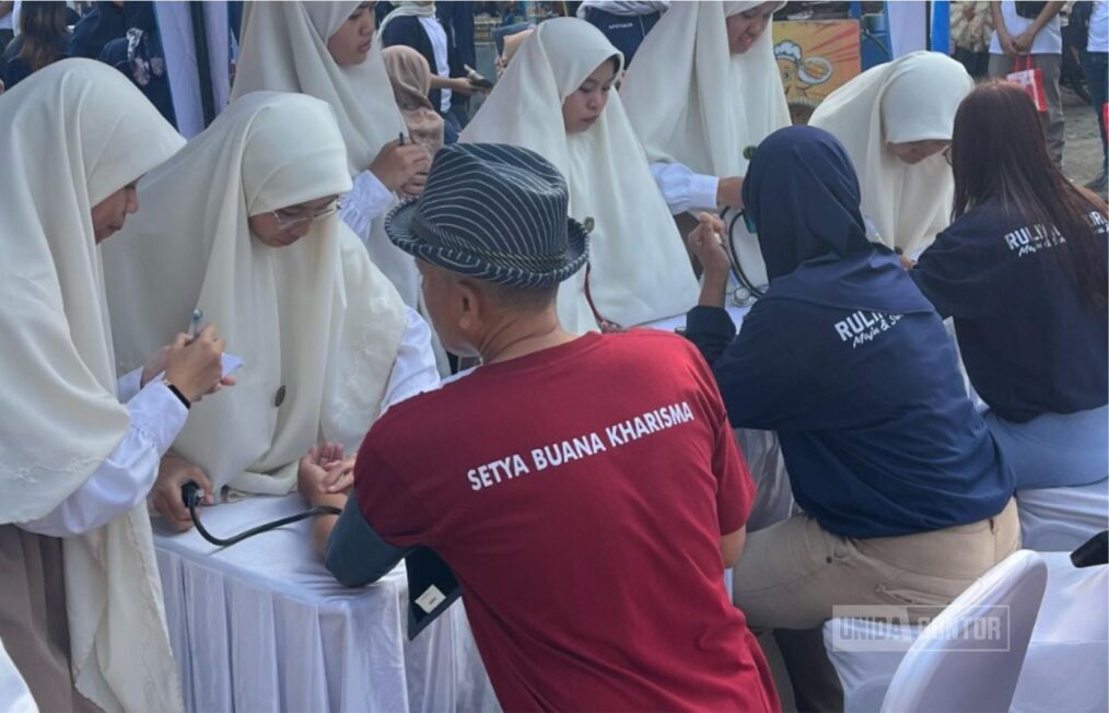 Mahasiswi FK UNIDA Gontor melakukan pemeriksaan kesehatan pada kegiatan May Day 2025 di Ponorogo.