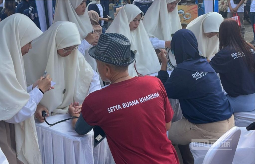 Mahasiswi FK UNIDA Gontor melakukan pemeriksaan kesehatan pada kegiatan May Day 2025 di Ponorogo.