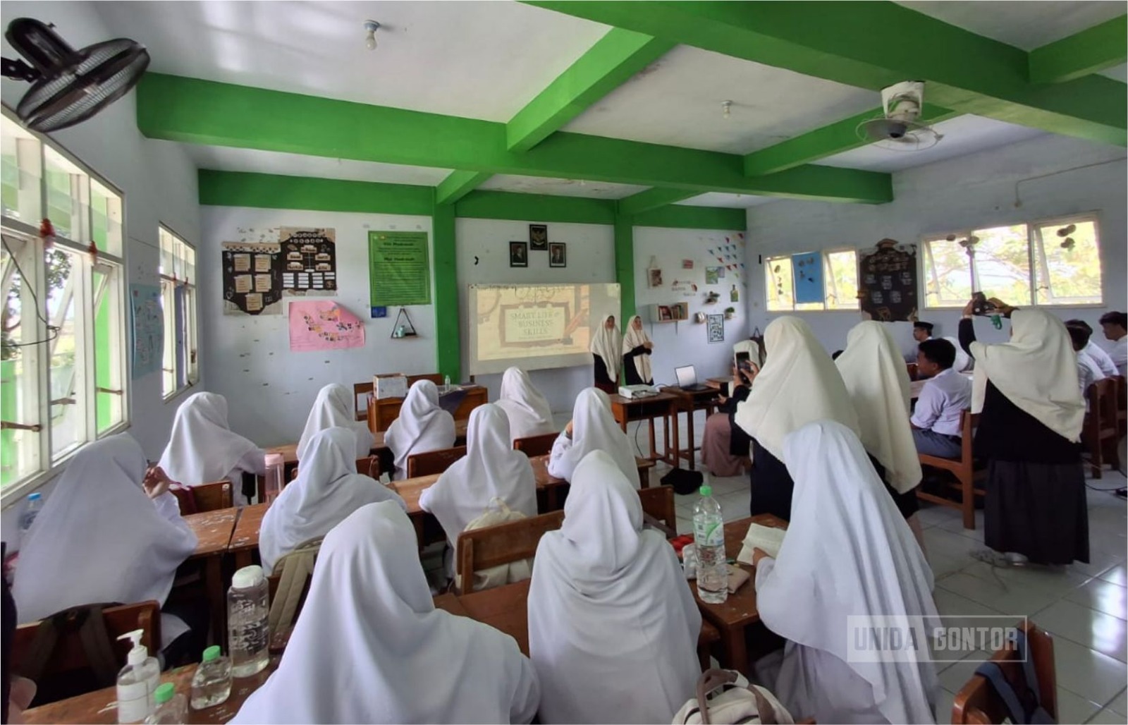 Mahasiswi Prodi Manajemen UNIDA Gontor membimbing siswa SMP/MA di Yayasan Fasihul Qur’an Pasuruan tentang literasi finansial, manajemen waktu, dan wirausaha melalui permainan Business Model Canvas.