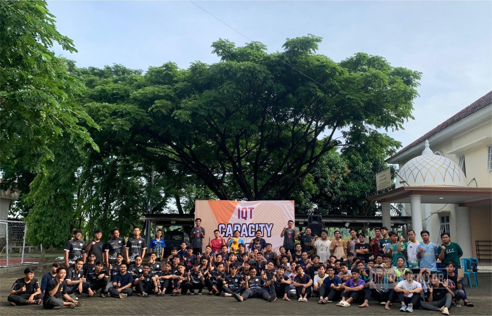 Pembukaan IQT Capacity Building di depan Gedung Sirah Nabawiyyah UNIDA Gontor; Kaprodi menabuh gong, disaksikan dosen dan mahasiswa.