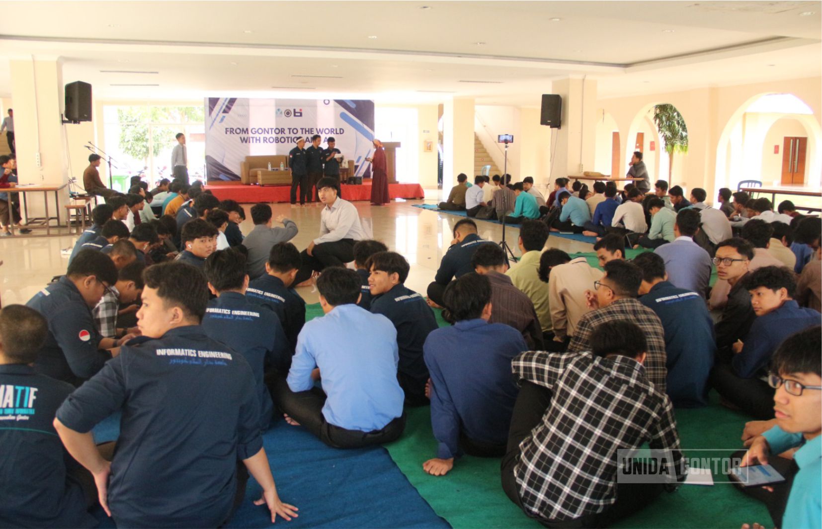Mahasiswa UNIDA Gontor mengikuti seminar “From Gontor to the World with Robotics and AI” di Lobby Gedung Terpadu bersama narasumber membahas inovasi teknologi dan kecerdasan buatan.