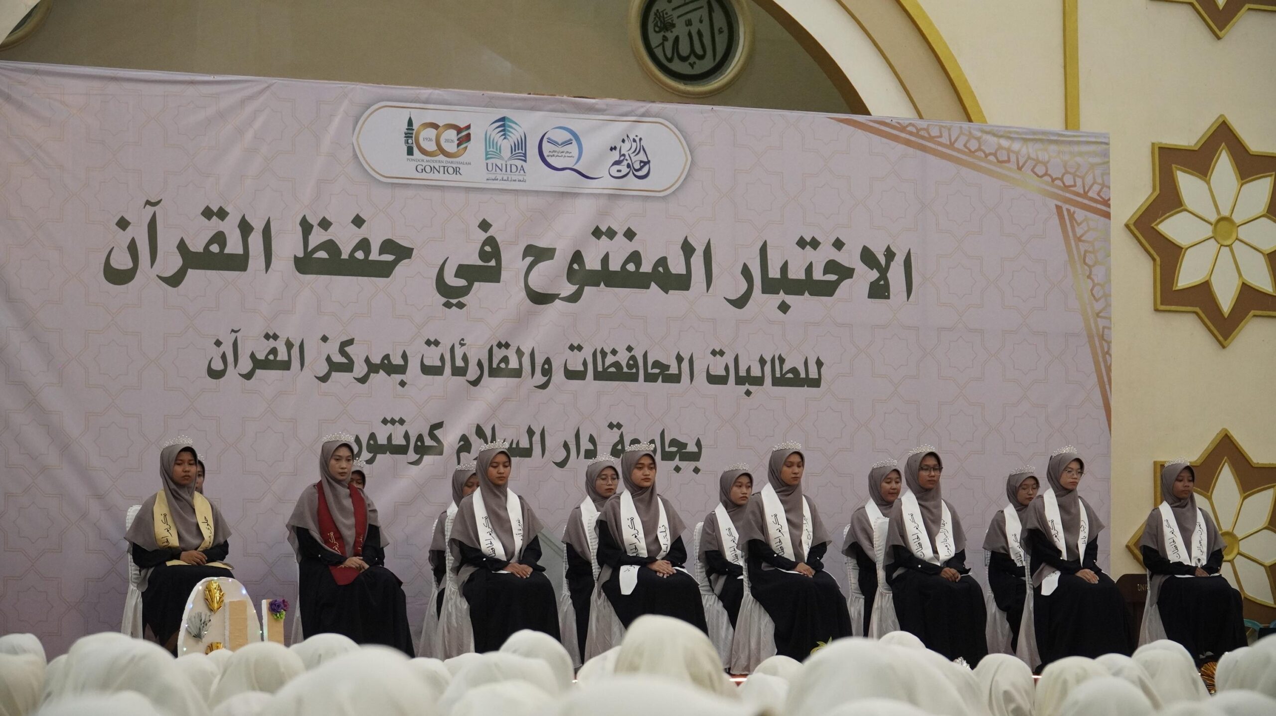 Mahasiswi memperdengarkan hafalan pada Ujian Tahfidz Terbuka 2025 di UNIDA Gontor, disimak ustadzah penguji dalam suasana khidmat.