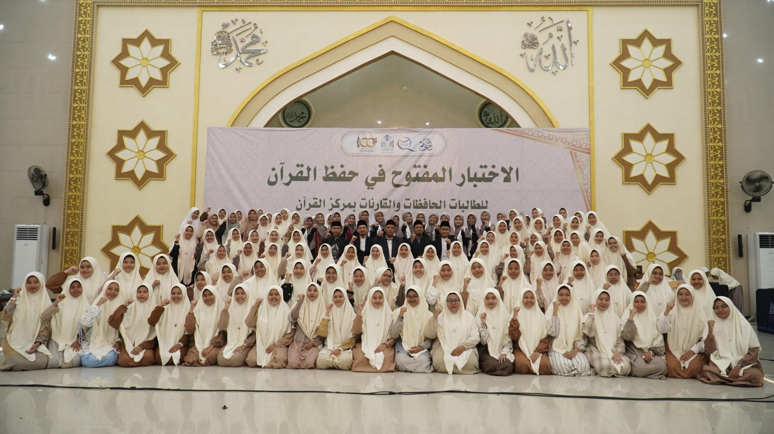 Mahasiswi memperdengarkan hafalan pada Ujian Tahfidz Terbuka 2025 di UNIDA Gontor, disimak ustadzah penguji dalam suasana khidmat.