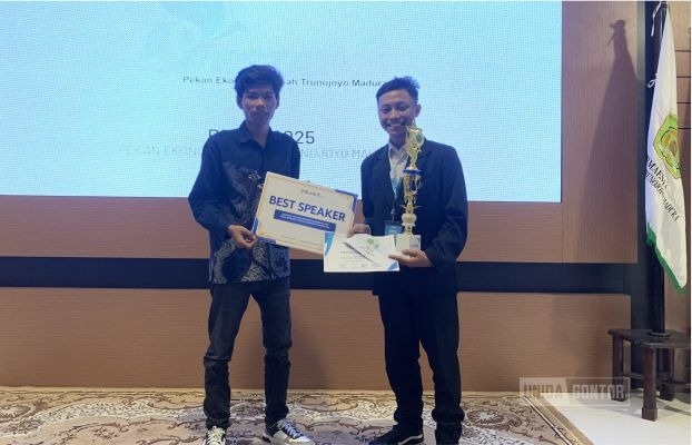 Fajar Satriyawan Wahyudi, mahasiswa Hukum Ekonomi Syariah UNIDA Gontor, menerima penghargaan Best Speaker dan Inovator Muda pada PESTA 2025 di Universitas Trunojoyo Madura, dengan latar banner acara.