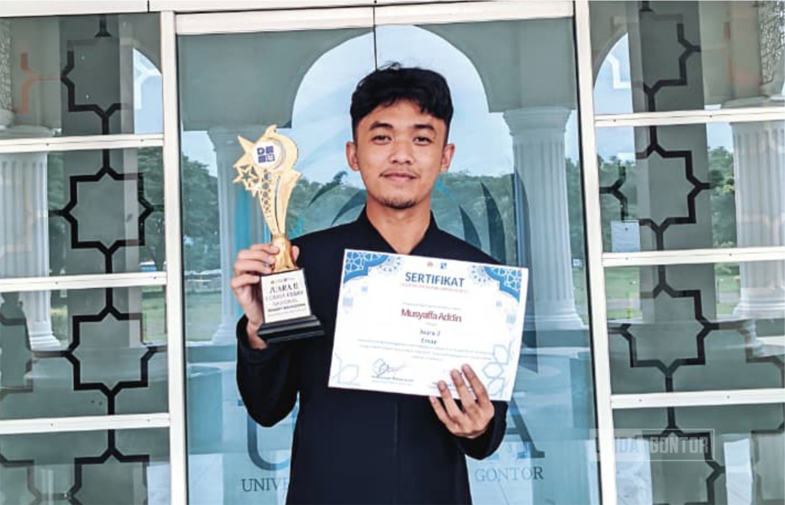 Mahasiswa Ekonomi Islam UNIDA Gontor, Musyaffa Addin, berpose dengan piagam penghargaan juara lomba esai nasional dan internasional.