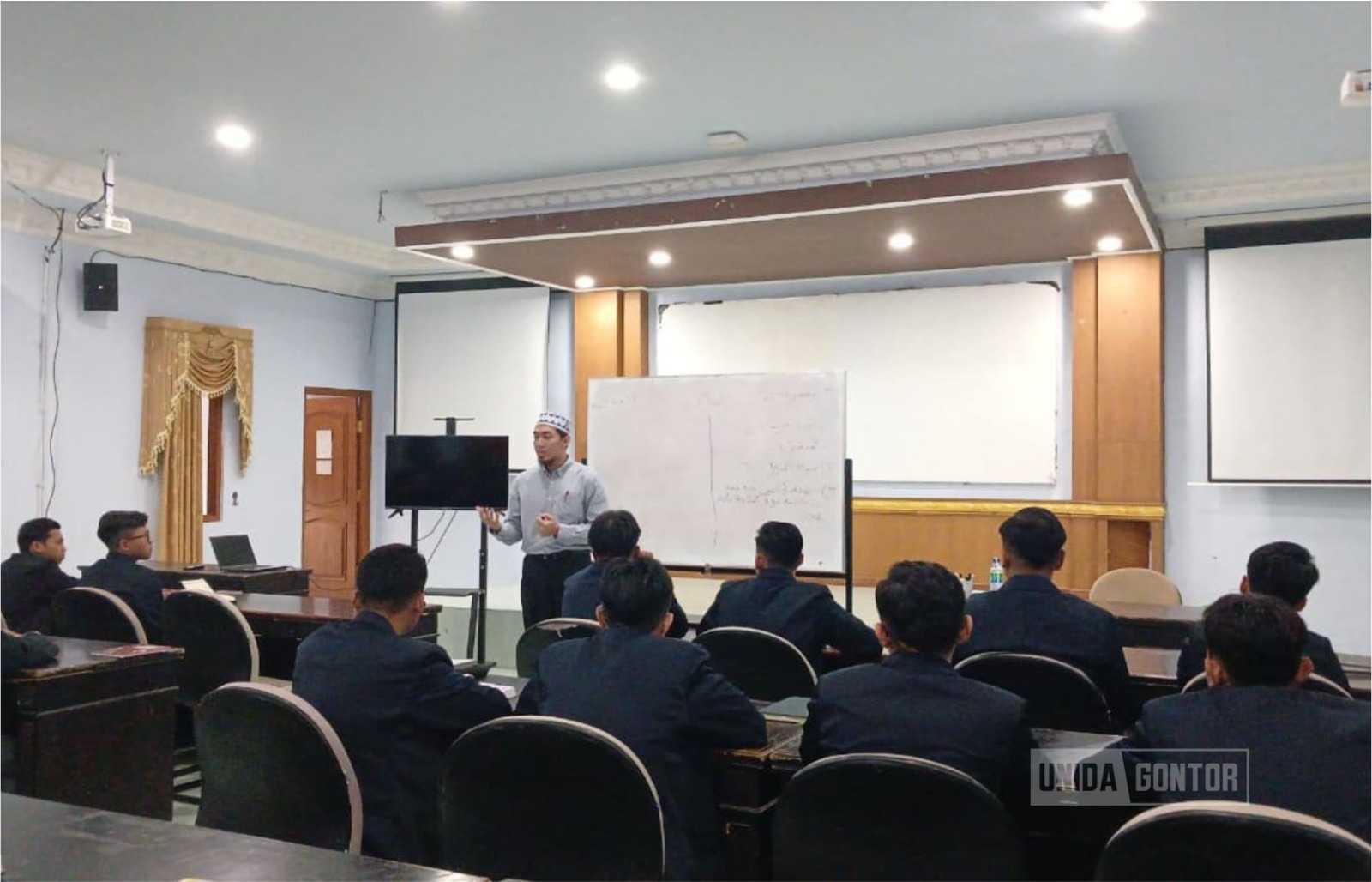 Peserta DQ MAIK Malaysia mempraktikkan microteaching bahasa Arab di Hall Unida Inn, didampingi dosen Pusdiklat UNIDA Gontor dan diikuti mahasiswa sebagai pelajar.