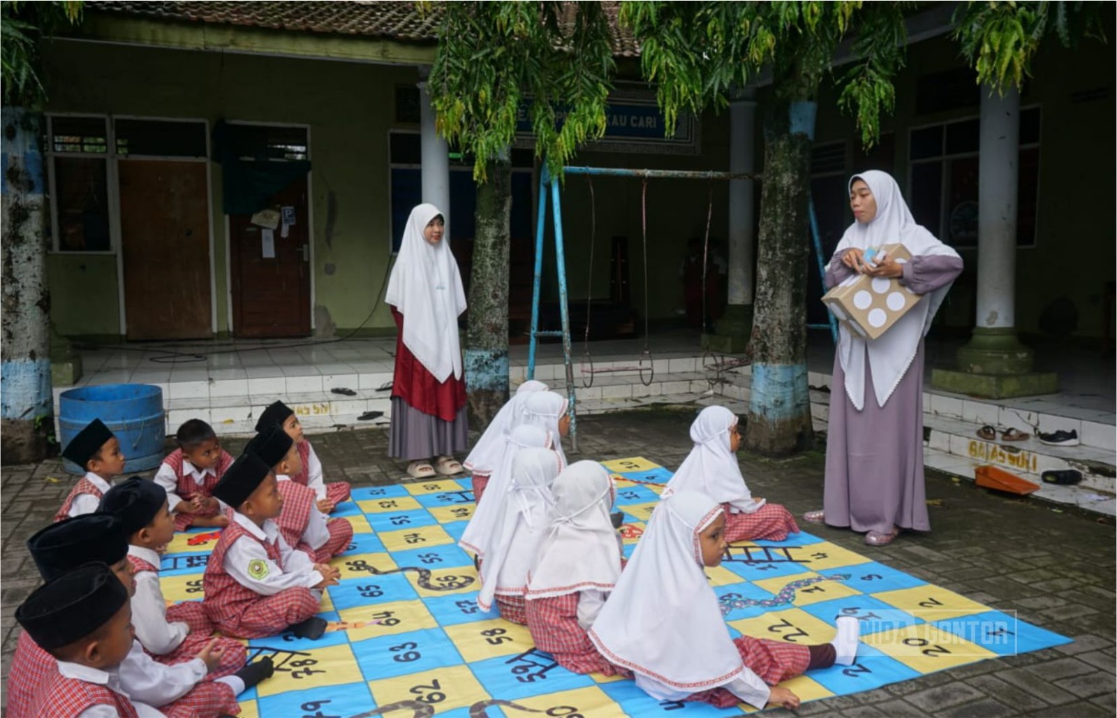 Siswa kelas 1 MI Nurussalam bermain ular tangga edukatif sambil melafalkan kosakata bahasa Arab, didampingi tim PKM UNIDA Gontor.
