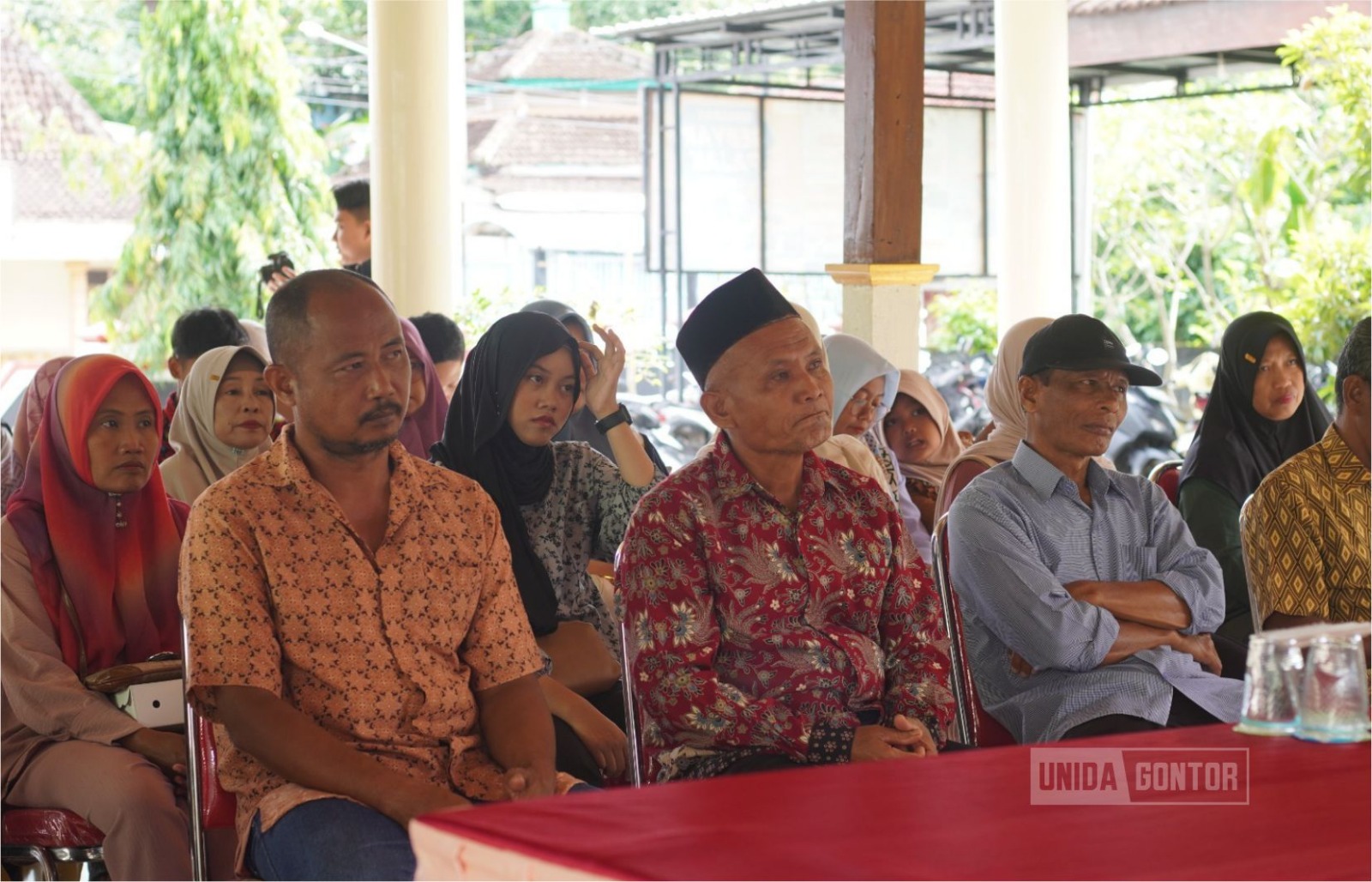 Mahasiswa KKN Tematik 38 UNIDA Gontor memberikan sosialisasi hukum bahaya judol dan pinjol kepada warga Desa Nailan di Balai Desa.